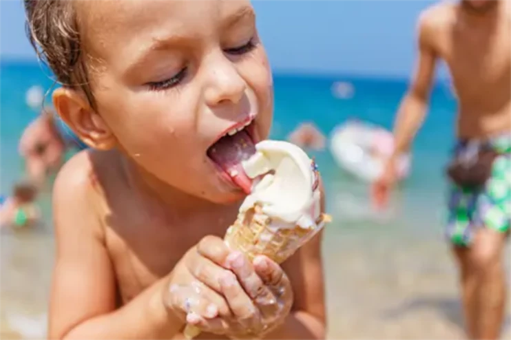 Child eating an icecream at the beach